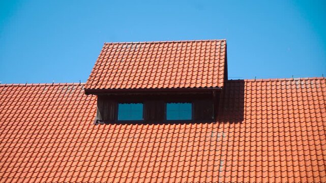 Terracotta Roof Tiles With Wooden Dormer Windows Under Blue Sky