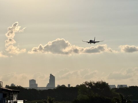 Airplane flying over Colegiales, Argentina, with city skyline in the background.