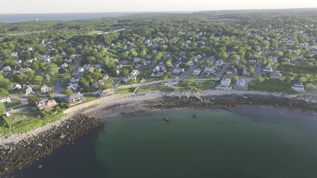 Luftbildpanorama von Rockport in Massachusetts bei Sonnenuntergang. Blick von der Meerseite auf den K&uuml;stenort mit Hafen, K&uuml;stenlinie, Booten und warmem Abendlicht &uuml;ber dem Atlantik.