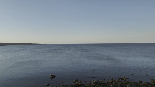 Luftbildpanorama von Rockport in Massachusetts bei Sonnenuntergang. Blick von der Meerseite auf den K&uuml;stenort mit Hafen, K&uuml;stenlinie, Booten und warmem Abendlicht &uuml;ber dem Atlantik.