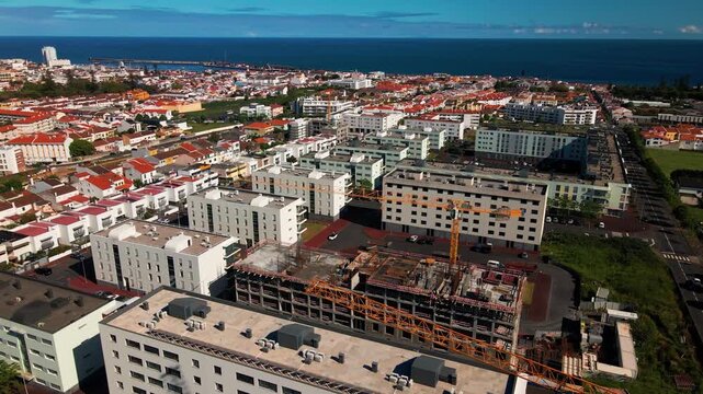 Aerial view of construction site crane and buildings in Ponta Delgada