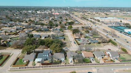 Obraz premium Aerial view captures the contrast between established suburban residential streets and the nearby commercial infrastructure, including a large parking lot and highway corridor in Plano, TX