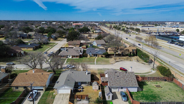 Suburban cul de sac aerial captures circular street design dense housing typical of residential growth. Tree lined backyards clean roof profiles characterize established neighborhood, Plano, TX
