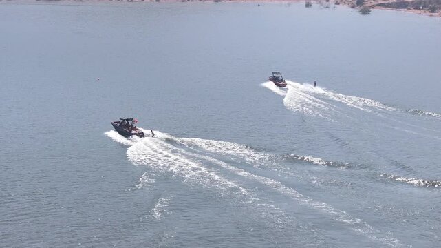 Two Speedboats Towing Water Skiers Across Calm Blue Water, Aerial View