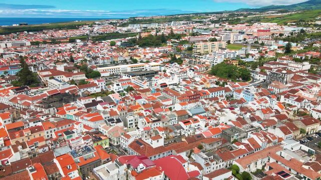 Aerial landscape panorama of Ponta Delgada city with orange roofs and green hills
