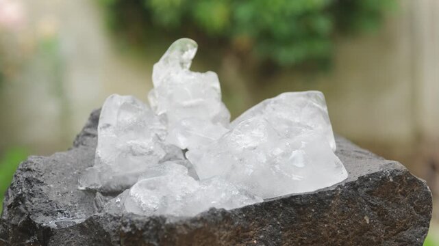 Chunks of solid ice on black volcanic rock in the process of melting
