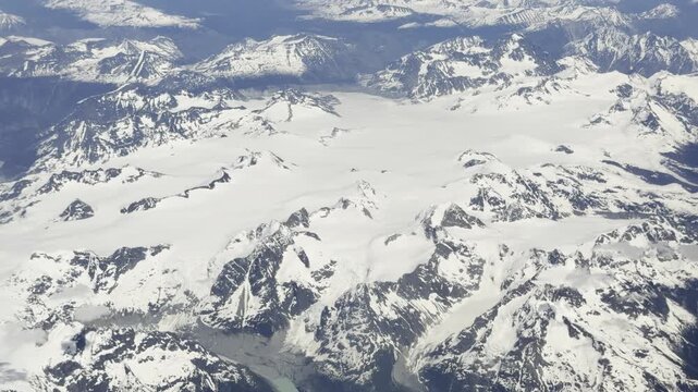 Dark Nunatak Peaks Breaking Through a Still White Icefield Plateau