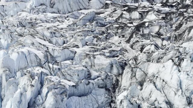 Deep fissures and dark debris streak the face of Lamplugh Glacier