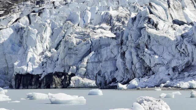 Sunlit crevassed ice wall of Lamplugh Glacier meets the waterline