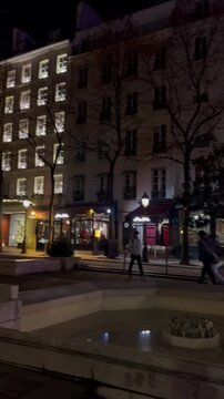 EDITORIAL USE ONLY: Vertical POV travel vlog panning from the historic Sorbonne Chapel to a traditional illuminated Parisian cafe at night in Paris, France.