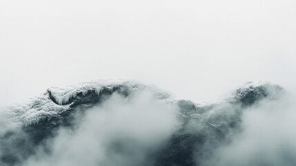 Obraz premium Frozen mountain peak shrouded in mist.