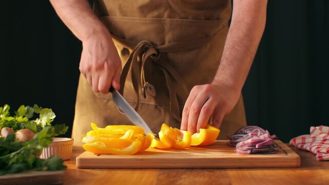 Man cut yellow sweet pepper, Chef hands with knife for onion, cutting and preparation with cooking for dish. Restaurant, culinary service and cook with skills for catering, business and hospitality by
