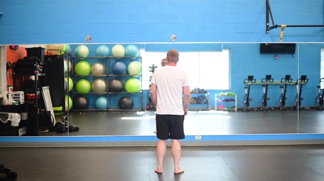 Man working out in the gym open space big mirror bright exposure