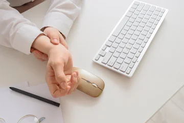 Fototapeten Musik Person holding wrist near computer keyboard and mouse  © Pixel-Shot