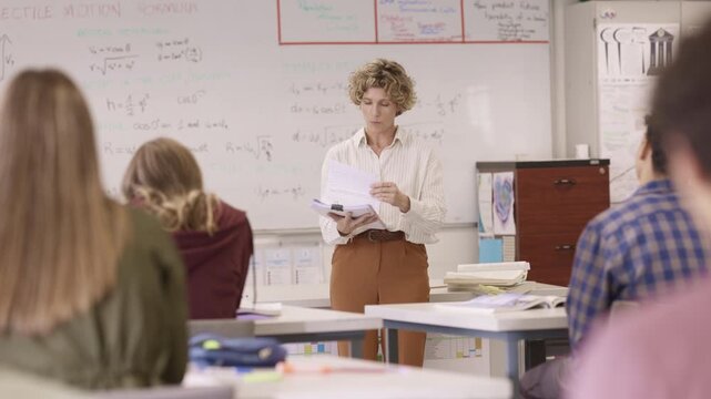 Mature teacher explaining lesson to teenagers student