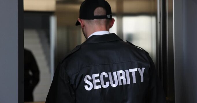 Bodyguard using walkie talkie while entering elevator indoors