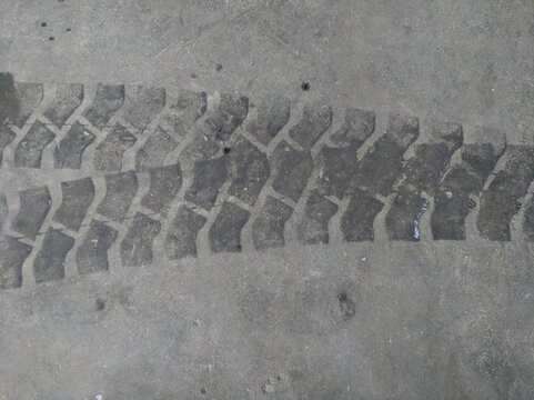Heavy vehicle tire track mark print on dark asphalt concrete road surface