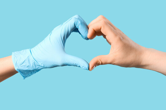 Hands forming a heart shape with one wearing a blue glove