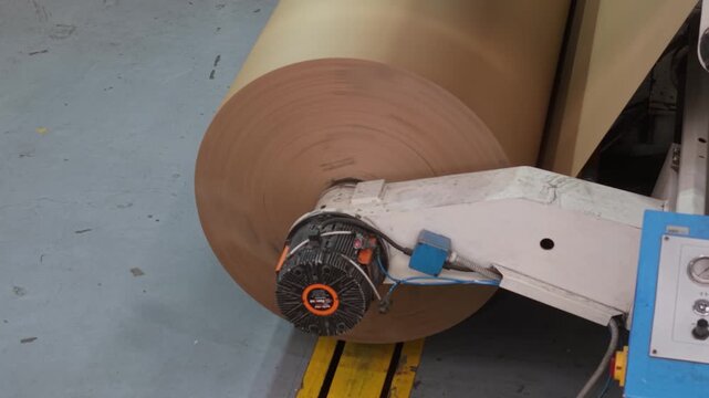 Bobina industrial de papel al final de una m&aacute;quina papelera. Producci&oacute;n de papel reciclado, manufactura, industria papelera, econom&iacute;a circular, tecnolog&iacute;a industrial