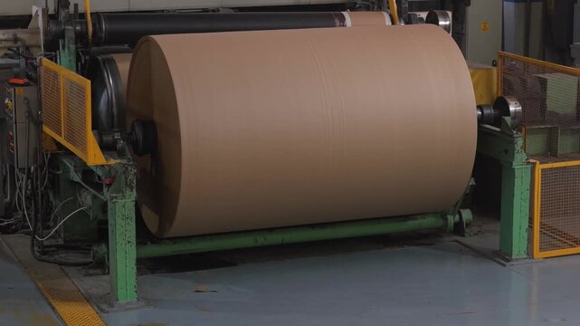 Bobina industrial de papel al final de una m&aacute;quina papelera. Producci&oacute;n de papel reciclado, manufactura, industria papelera, econom&iacute;a circular, tecnolog&iacute;a industrial