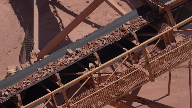 Conveyor Belt Transporting Crushed Rock Through an Industrial Quarry Facility