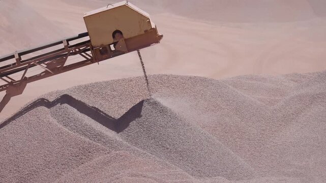 Industrial Conveyor Depositing Crushed Stone Onto a Growing Aggregate Stockpile