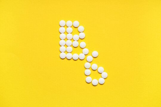Vitamin B6 pills on yellow background