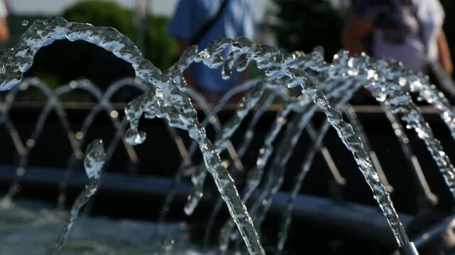 Urban fountain and city life. 
Streams of water are neatly aligned in a row.