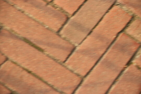 Herringbone pattern red clay brick paver surface texture with herringbone pavement construction