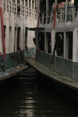 Obraz premium Two aged passenger river boats docked closely side by side at a pier with nautical, transportation