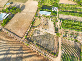 Naklejka premium Sustainable farmland with irrigation ponds, vegetable plots, banana cultivation, and farmhouse buildings in a rural countryside. Agricultural production. Land management. Sustainable agriculture.