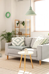 Fototapeta premium Cozy sofa and coffee table in interior of living room