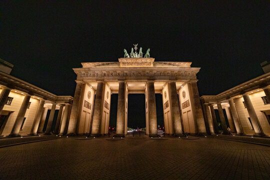 View of the illuminated Brandenburg Gate at night with its neoclassical columns and the Quadriga sculpture against the dark sky in Berlin, Berlin, Germany.