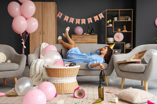 Young Asian woman with hangover lying on sofa after Birthday party at home