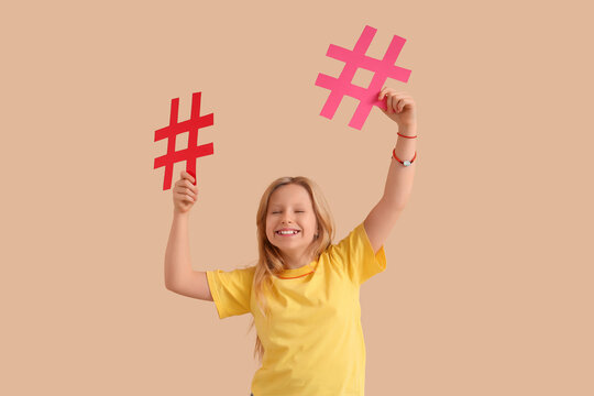 Cute teenage girl with hashtags on beige background