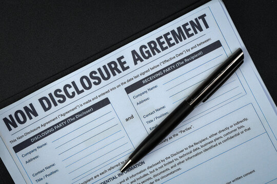 Serious legal document non disclosure agreement contract paper with pen awaits official signature representing quiet anxiety of business trust