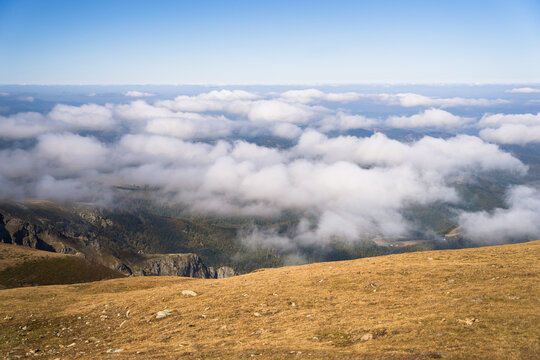 View of Botev Peak with rocky slopes and clouds drifting below the summit in Balkan Mountains, Lovech, Bulgaria.