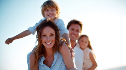 Fototapeta premium Joyful family vacationing by the sea, with a son on his mother's shoulders.
