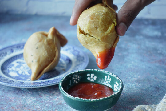 Enjoying indian street food singara with sauce 