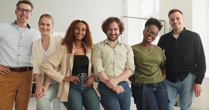 Business team colleagues in office portrait smiling. The group reflects diversity among people in a bright workspace, ideal for websites and recruiting. Symbol of teamwork trust and inclusion.