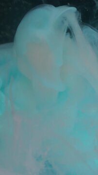 Vertical video. Cloud blend. Paint flow. Defocused pink blue color liquid drop swirl texture cracked light bulb vapor floating on abstract bokeh art background.