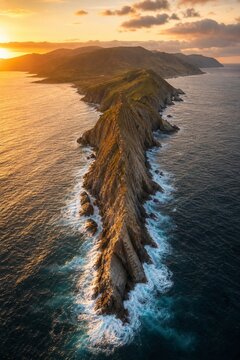 A sharp rocky point jutting into the sea with waves crashing.