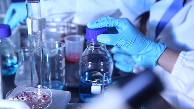 Female researcher's hands mixing solution through pipette at chemistry lab