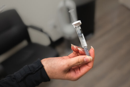 Medical Professional Holding Prefilled Syringe Before Handing Off to Nurse