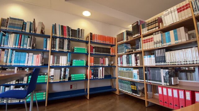 Bookshelves filled with rows of books and binders in a library, representing knowledge, education, and organized research material
