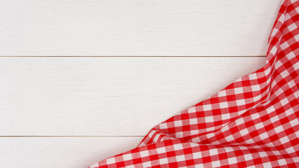 Obraz premium Wrinkled red gingham fabric on rustic white wood plank background, with copy space.