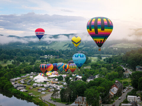 Hot Air Balloon Festival in Quechee, Vermont with colorful hot air balloons floating off the ground in the early morning light. Aerial drone photo taken June 21, 2026. 