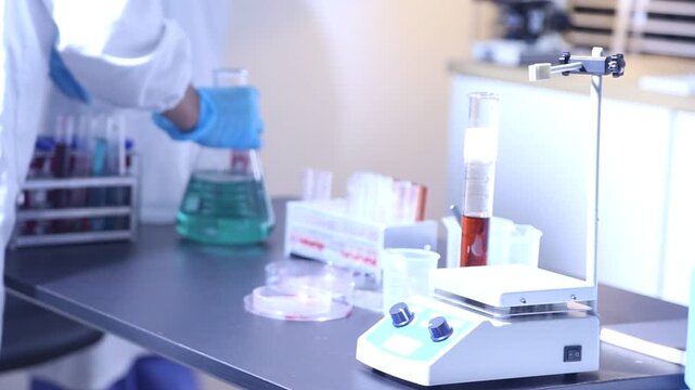 Female researcher's hands mixing solution through pipette at chemistry lab