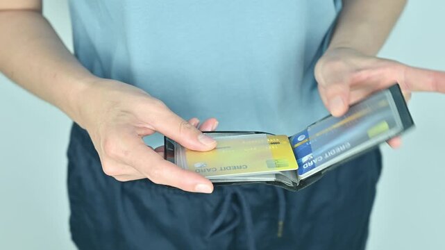 Cropped shot view of woman holding a credit card holder. This is a physical item used to store your cards to use the credit card account.