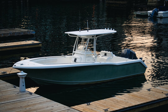 View of a white center console motorboat moored at a wooden dock in the South Boston Waterfront, Boston, Massachusetts, United States.